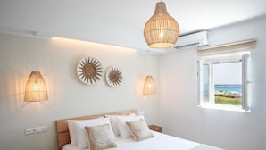 Un dormitorio con cama, lámparas de noche, decoración en la pared y una ventana con vistas.