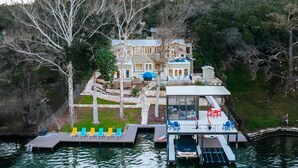 Une propriété située au bord d’un lac, dotée d’un quai, d’une piscine et d’une grande maison à plusieurs niveaux.