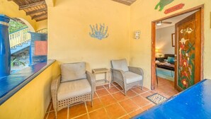 A room with two wicker chairs, a small table, and a decorative wall with a turtle sign.