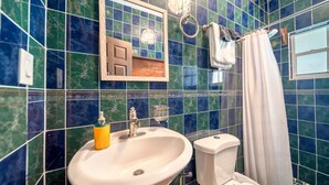 A bathroom with a sink, toilet, and a mirror.