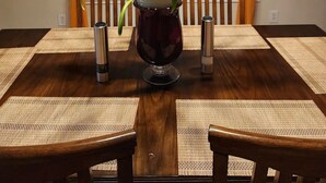 A dining table with a potted plant, two thermos flasks, and a wooden chair. - Cozy Glen Abbey retreat-sleeps-6 (Houston)