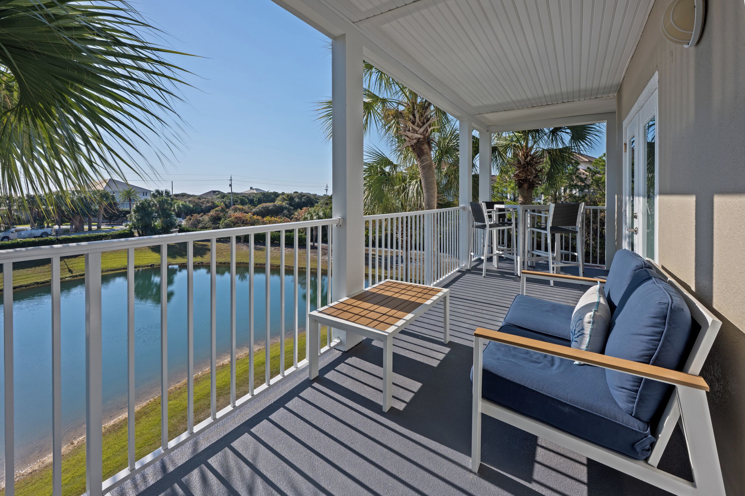 A covered outdoor area with a pool, seating, and a view of the landscape.