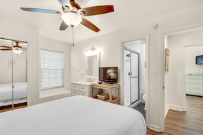 A bedroom with a bed, a vanity with a mirror, a television, and a ceiling fan. - Beach Service⛱️Beach View I 4👑Kings I 6BR Martinique at Port of Call (Miramar Beach)