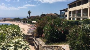 A resort with a pool, lounge chairs, and a view of the sea. - Studio Proche Mer, son Jardinet et sa Place de Parking Privés (Roquebrune-sur-Argens)