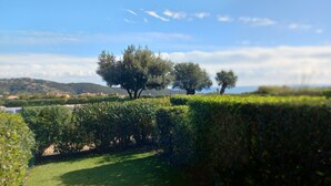 A lush green landscape with a well-maintained hedge, a clear sky, and distant hills. - Studio Proche Mer, son Jardinet et sa Place de Parking Privés (Roquebrune-sur-Argens)