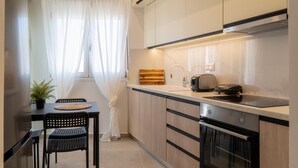 A modern kitchen with a built-in oven, a coffee maker, and a sink. - Pananos Sq. House II (Heraklion)