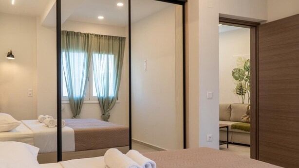 A hotel room with a bed, a desk, and a mirror. - Pananos Sq. House II (Heraklion)