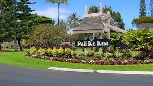 Placa de Pali Ke Kua com estrutura tradicional e jardim bem cuidado.