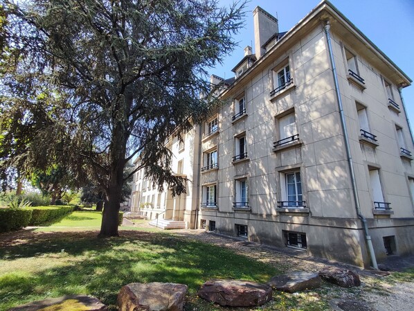 A multi-story building with a symmetrical facade, large windows, and a central entrance.