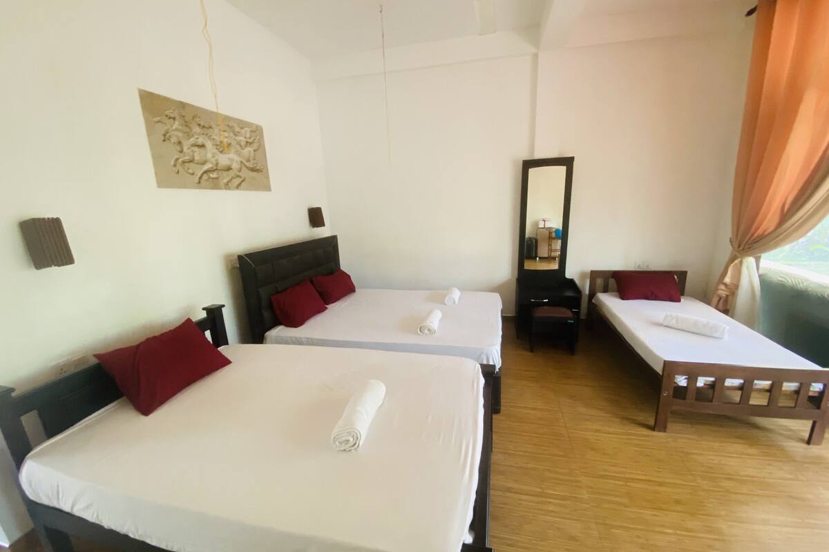 A hotel room with two beds, a large mirror, and a view of the outdoors.
