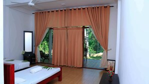 Un dormitorio con dos camas, un escritorio, una silla y un ventanal con cortinas.