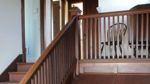 Un escalier en bois, doté d’une rampe, mène à un palier.
