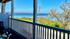Ein Balkon mit Blick auf das Meer und einer Steinmauer.