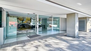 Ein modernes Gebäude mit großen Glasfenstern, Fliesenboden und einer Betonstütze.