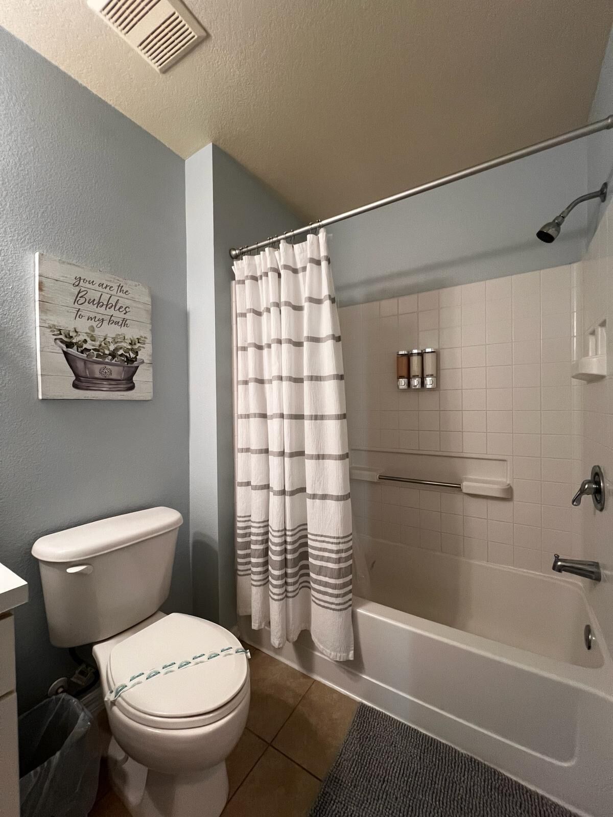 Une salle de bain équipée de toilettes, d’une douche et d’un panneau fixé au mur.