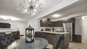 A modern kitchen with dark cabinetry, stainless steel appliances, and a central island. - Bright and Cozy suite, great for work stays or vacations heart of Campbell River (Campbell River)