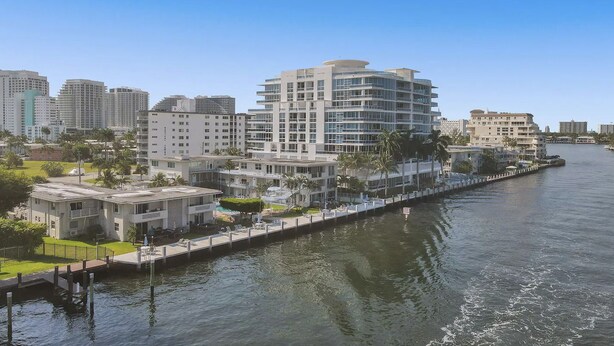 A waterfront hotel with multiple floors, a dock, and a view of the water.
