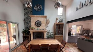 Una cocina amplia con una gran mesa de comedor, chimenea y decoración moderna.