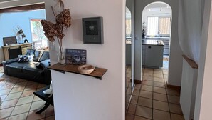 Una sala de estar moderna con un sofá, una mesita con un cuenco y un dispositivo montado en la pared.