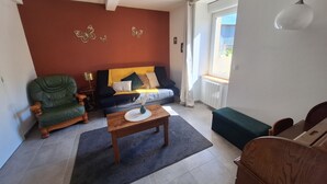 Ein Wohnzimmer mit einer Couch, einem Sessel und einem Couchtisch.