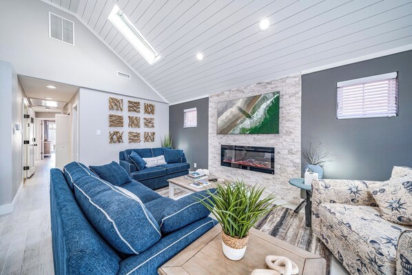 A modern living room with a sofa set, a fireplace, and a large TV mounted on the wall. - Beach Block In OCNJ between 7th & 8th St! - 3 Bd/2 Bath, Sleeps 10 (Ocean City)