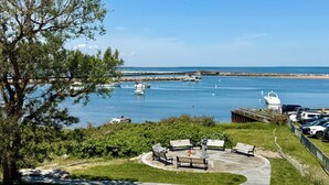 A coastal park with benches, a paved walkway, and a view of boats on the water. - Old Bakery Inn (Block Island)