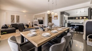 Un espace repas moderne avec une table en bois dressée pour six personnes, entourée de chaises à revêtement gris.
