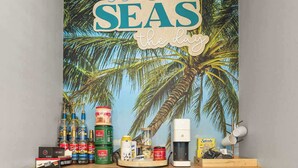 A kitchen area with a wooden countertop, two wicker chairs, a coffee machine, and a wall with a tropical-themed poster. - THe Pirates Hideout - slide•gameroom•ada•elevator•rockwall (Pensacola)