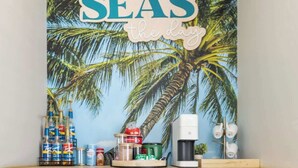 A kitchen area with a wooden countertop, two woven chairs, a small woven basket, and a wall-mounted shelf with various items. - THe Pirates Hideout - slide•gameroom•ada•elevator•rockwall (Pensacola)