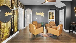 A modern living room with a round coffee table, leather armchairs, and a ceiling fan. - THe Pirates Hideout - slide•gameroom•ada•elevator•rockwall (Pensacola)