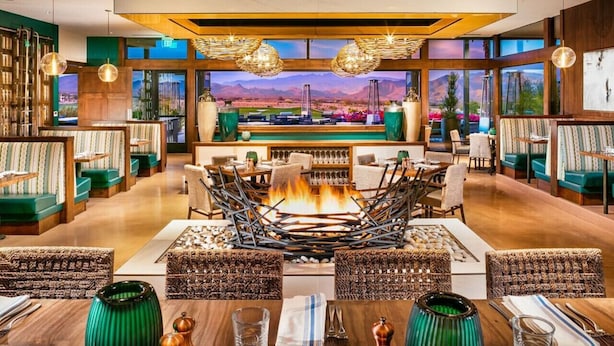 A spacious lobby with a central fire feature, seating areas, and large windows offering a mountain view. - Upscale Furnished Resort Home (Rio Verde)