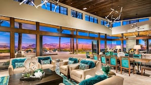 A spacious living area with a large window overlooking a scenic mountain view. There is a dining area with a table and chairs. - Upscale Furnished Resort Home (Rio Verde)