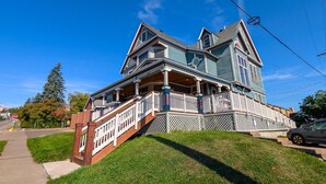 A two-story house with a front porch and a small staircase leading up to it. - Harris House 4 | On Hospital Campus (Duluth)