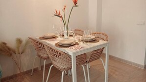 Ein Esstisch, gedeckt mit Tellern, Gläsern und einer Blumenvase.