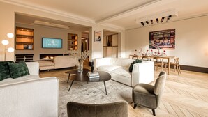 A modern living room with a fireplace, a television, and a dining area with a table and chairs. - Stéphanie I (Brussels)