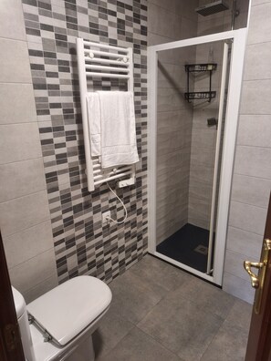 Een douche, handdoeken, zeep, shampoo