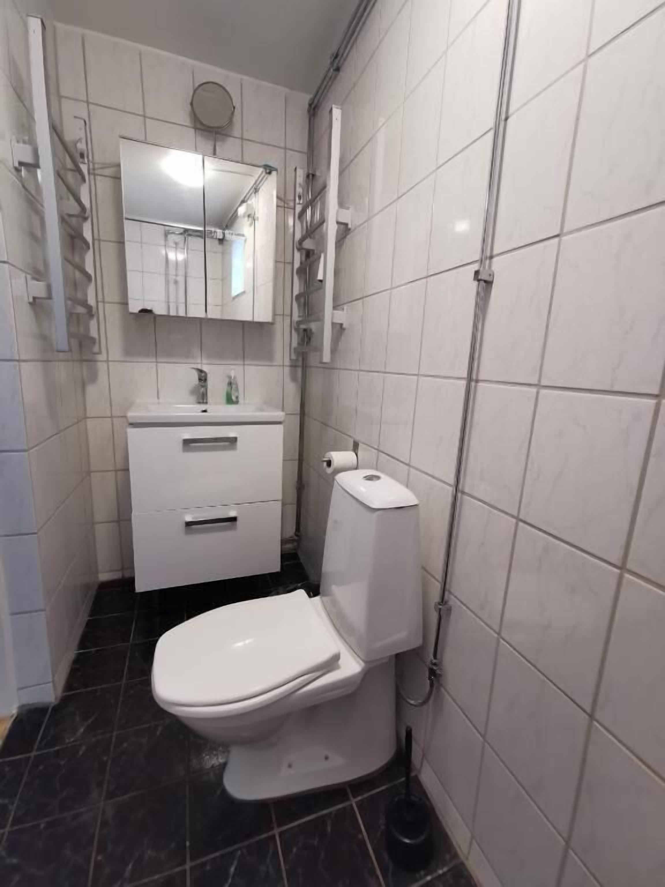 A small, modern bathroom with a toilet, sink, and mirror.