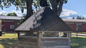 A small wooden structure with a pitched roof, surrounded by grass and trees. - Västervik rum och stugor (Vastervik)