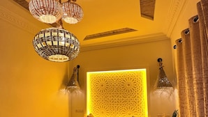 A bedroom with a patterned bedspread, a decorative headboard, and multiple hanging lamps. - Riad dreams dades  (Ait Sedrate Jbel El Soufla)
