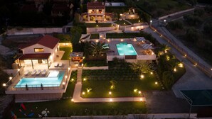 A large property with multiple swimming pools, a well-maintained garden, and a spacious outdoor area with seating.