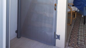 A wooden staircase with a mesh gate at the bottom. - Appartement vue sur mer (Soulac sur Mer)