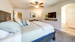 A bedroom with a bed, ceiling fan, TV, and a door. - Colorado Springs Family Home ~ 10 Mi to Downtown! (Colorado Springs)