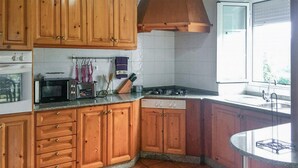Eine Küche mit Holzausstattung, einer Mikrowelle, einem Toaster und einem Herd.
