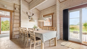 A wooden interior with a dining table, chairs, and a large window offering a view of the outdoors. - Beautiful home in Hemmet with kitchen (Hemmet)