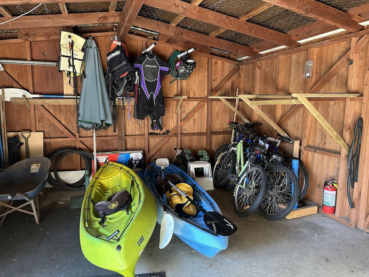 En garage med kajakker, cykler og forskelligt sportsudstyr.