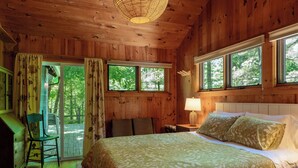 Une chambre dans une cabane en bois, avec un lit, un bureau et une chaise.