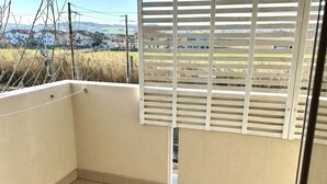 Un balcon donnant sur des maisons et un champ.