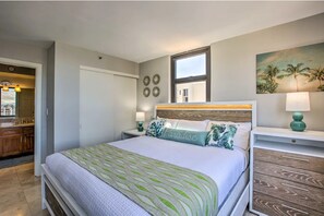A bedroom with a bed, a nightstand, a window, and a painting on the wall. - Stunning Ocean View Retreat W/ Free Parking. (Honolulu)