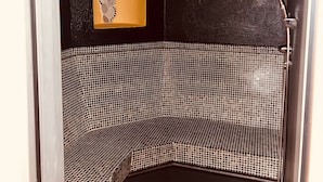 A corner bathtub with mosaic tiles, a small alcove with a mosaic arch, and a shower area. - Holiday Apartment 'Residenz Zirmer Wohnung Feuer' with Mountain View, Shared Garden and Wi-Fi (Castelrotto)