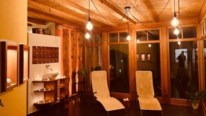 A room with wooden ceiling beams, two lounge chairs, a wall-mounted wine rack, and a large window. - Holiday Apartment 'Residenz Zirmer Wohnung Feuer' with Mountain View, Shared Garden and Wi-Fi (Castelrotto)